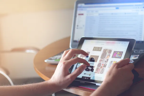 Hands of a person typing on a tablet